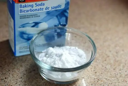 An open box of baking soda placed on a refrigerator shelf to absorb stubborn odors.