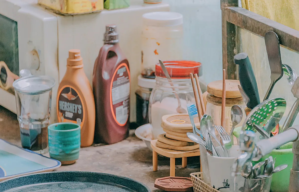 Baking soda and vinegar containers displayed together as separate kitchen cleaning tools on a table.