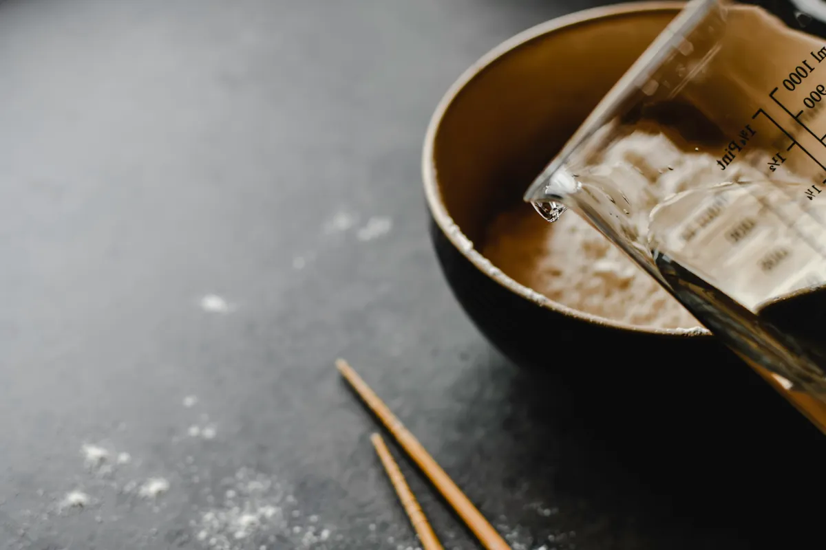 Baking soda and vinegar ingredients separated in bowls before mixing DIY solutions.
