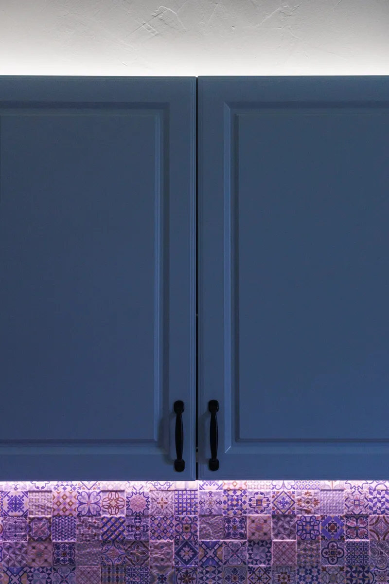 A cabinet door showing clean, shiny handles and hinges next to the cabinet face.