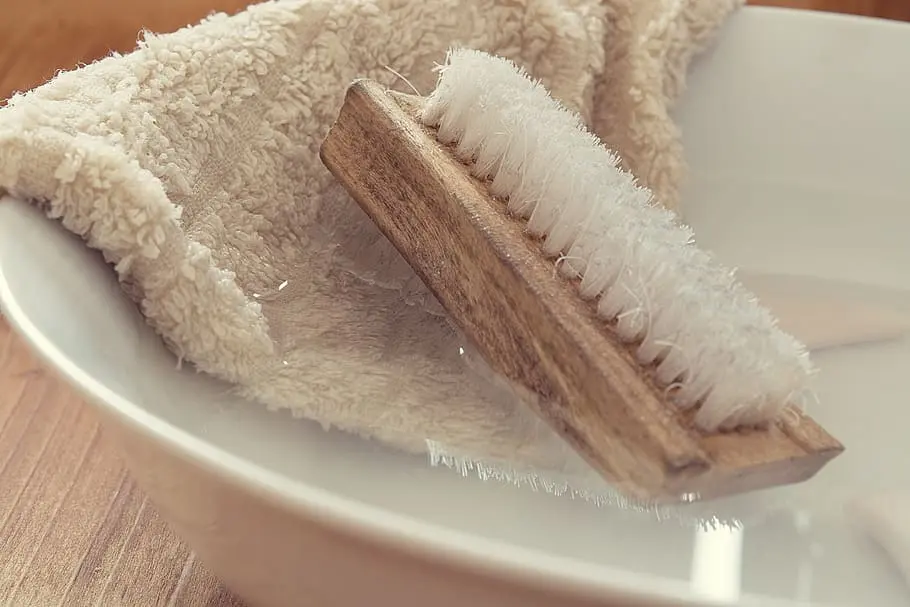 Soft brush cleaning tight corners and vent openings inside a microwave.