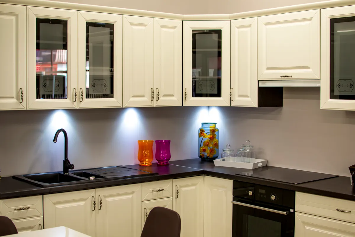 Checking painted kitchen cabinet doors for grease buildup and sticky residue during a deep clean.