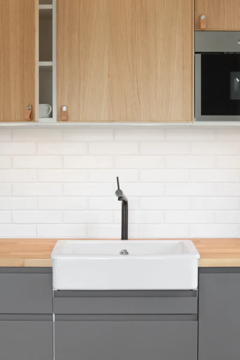 A sparkling clean white ceramic kitchen sink fully dried and ready for heavy daily use.