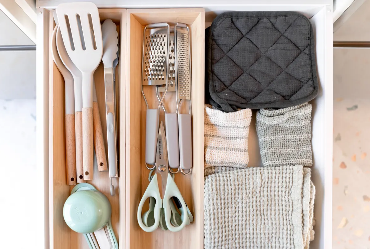 A deep kitchen drawer holding heavy pots and pans organized neatly on the bottom.
