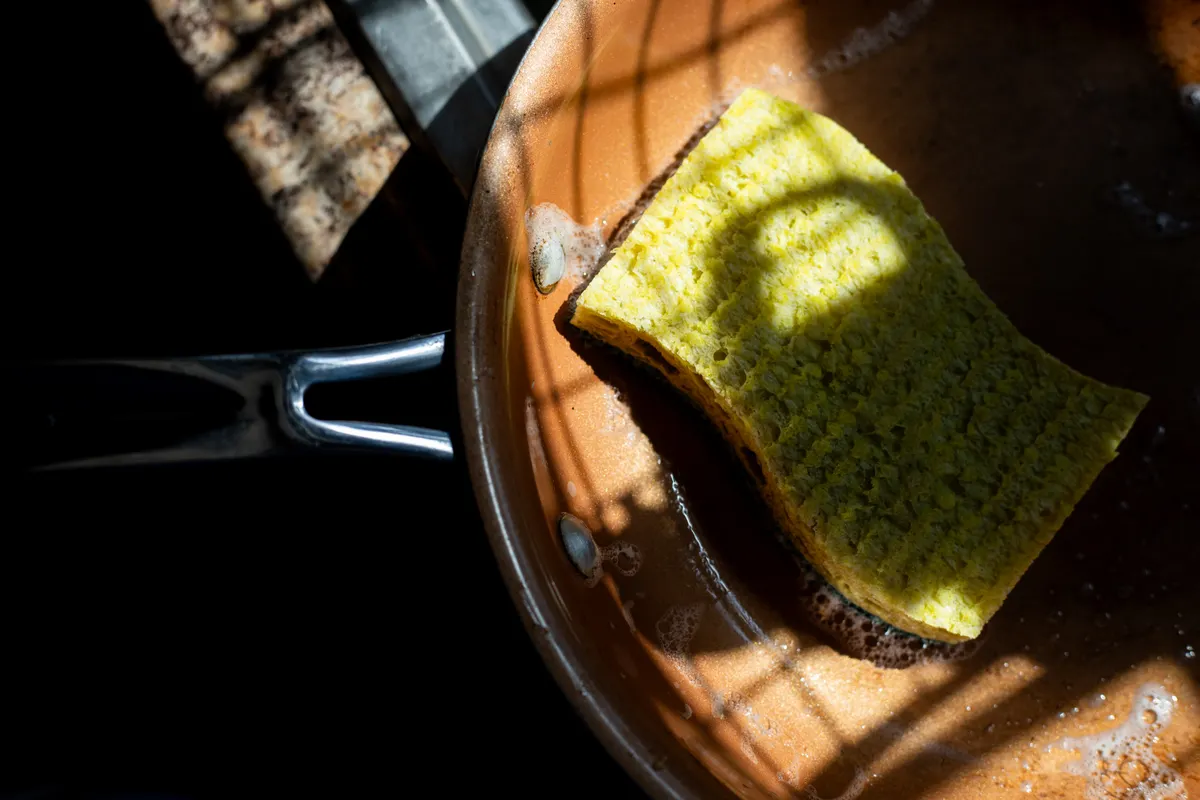 A small set of tools and mild soap used to clean utensil trays without scratching surfaces.