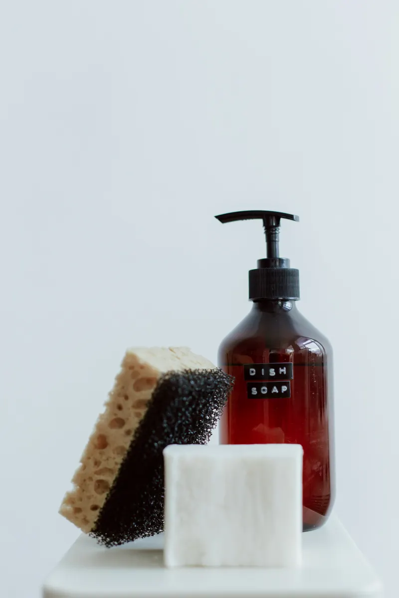 Mild dish soap and simple eco friendly cleaning ingredients arranged on a kitchen counter.