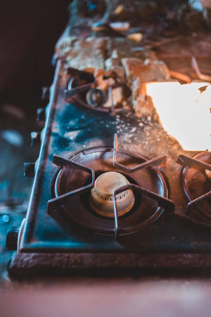 Close up of gas burner components showing accumulated residue that requires careful cleaning attention.