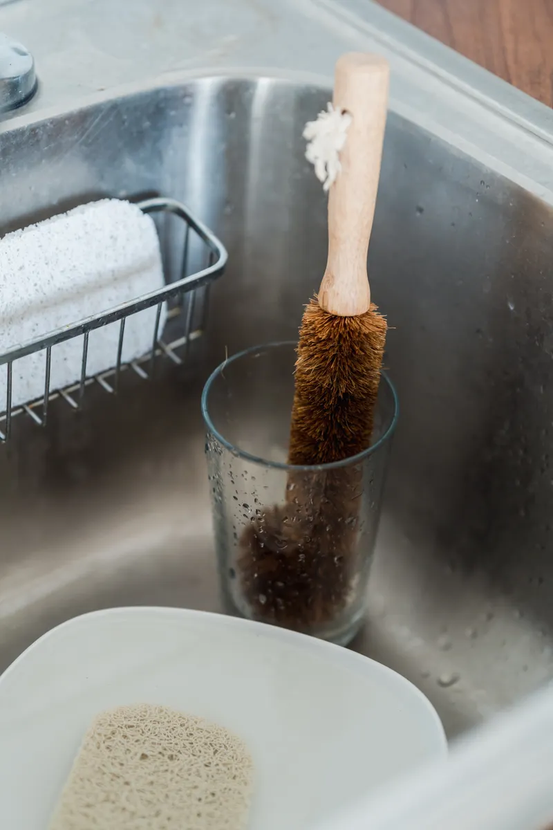 Using a gentle soft brush to clean dishwasher racks without causing scratches.