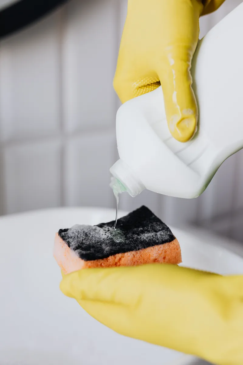 A soft sponge and mild dish soap used for cleaning laminate surfaces safely