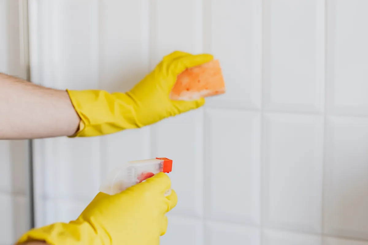 Gentle cleaning tools and baking soda paste used safely on kitchen tile and grout lines.