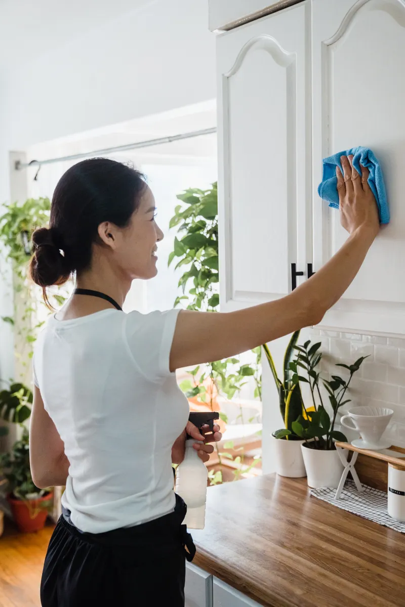 Organized kitchen upper cabinets with clean shelves and wiped surfaces.