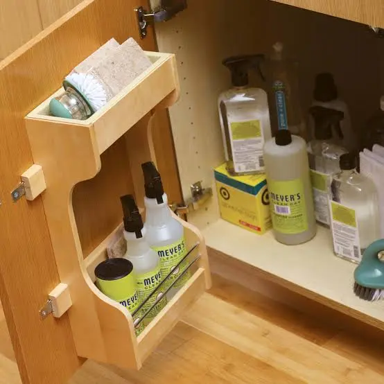 Safe cleaning supplies and microfiber cloths gathered for washing kitchen cabinets and drawers