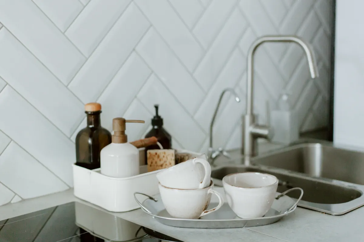 A stocked cleaning caddy with soap and baking soda under the kitchen sink.