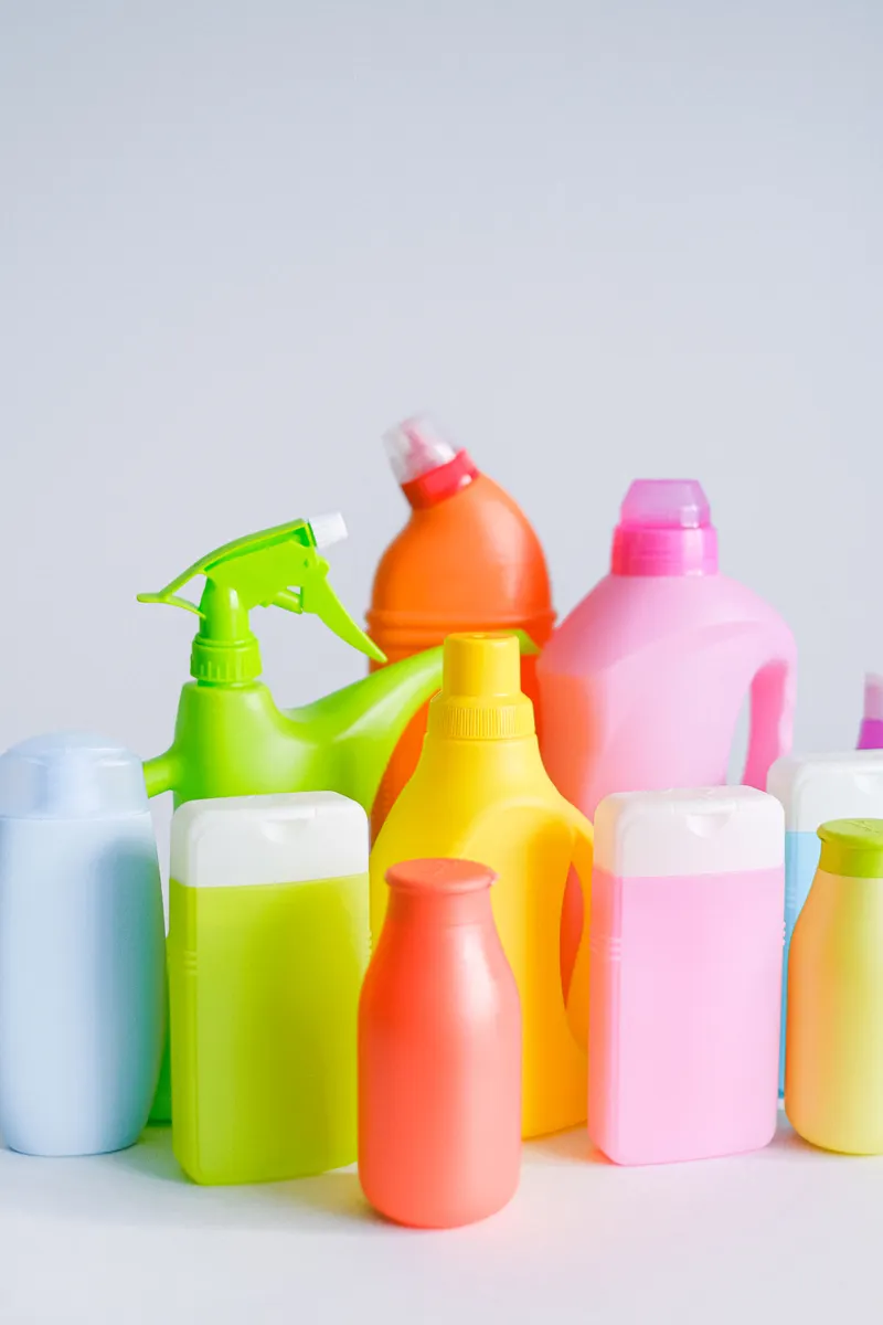 Assorted kitchen cleaning supplies including spray bottles and folded fabric cleaning cloths