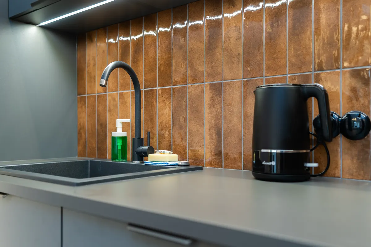 Modern kitchen setup showing a well maintained sink requiring regular weekly cleaning.