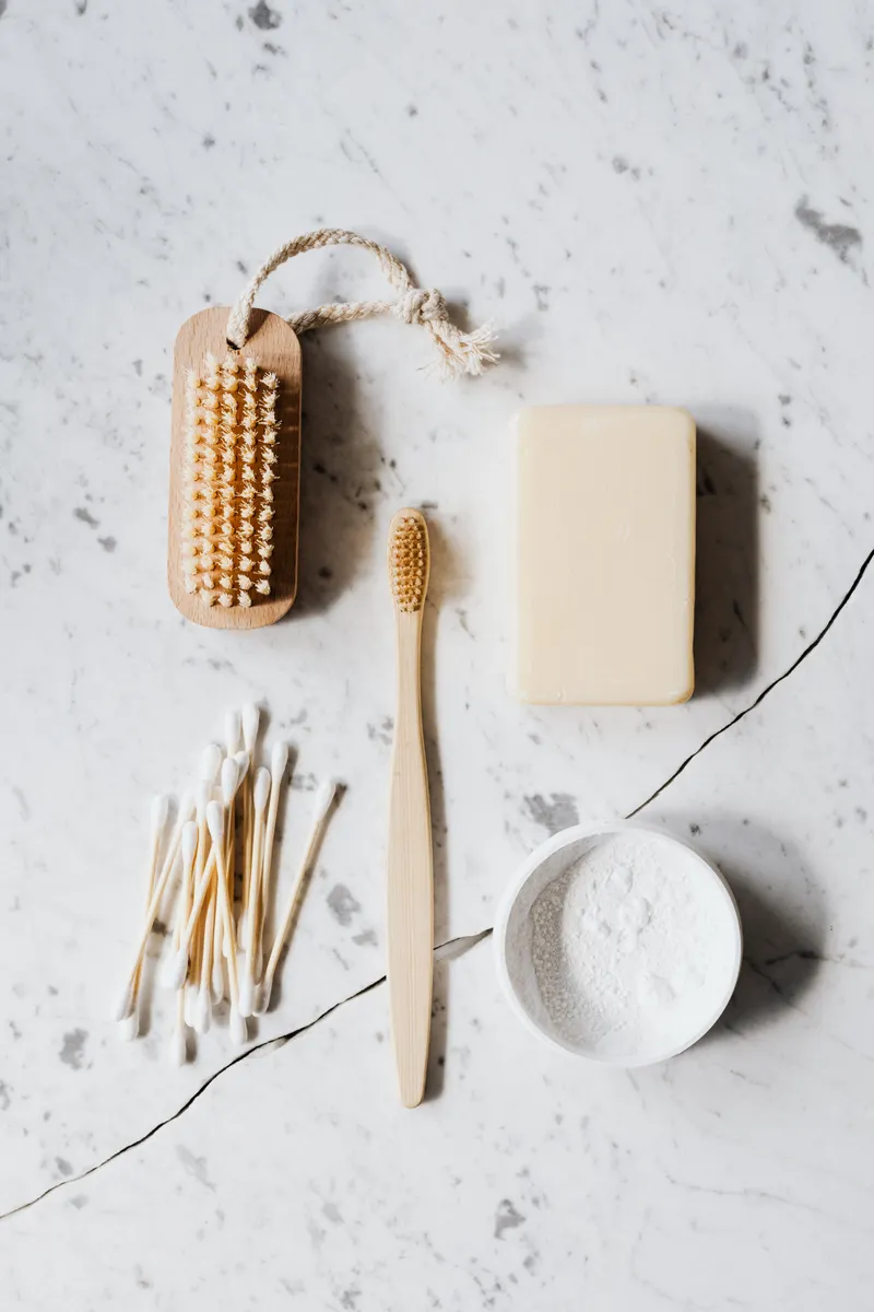 Baking soda and cleaning cloths arranged neatly on a kitchen counter for natural refrigerator care.