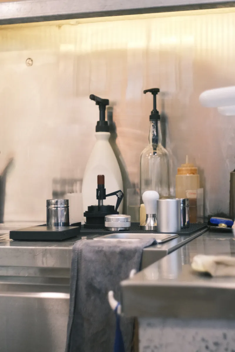 Organized cleaning supplies arranged neatly on a kitchen counter for a structured top to bottom routine.