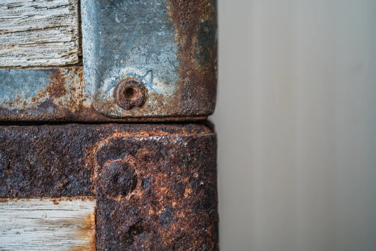 Detailed view of antique metal hardware showing corrosion and pitting that may need professional restoration.