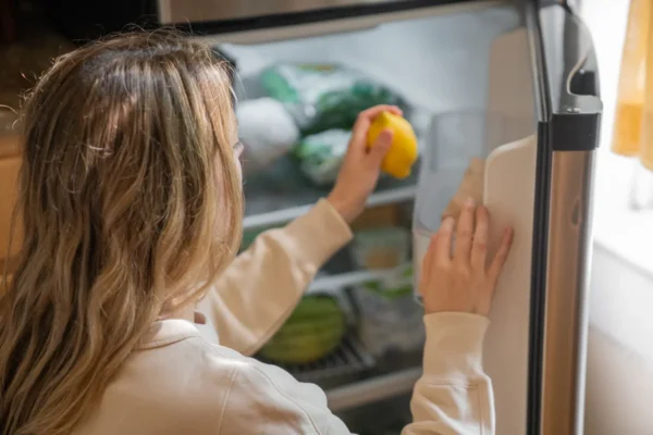 A clean modern refrigerator interior with organized shelves and produce drawers ready for a cleaning routine