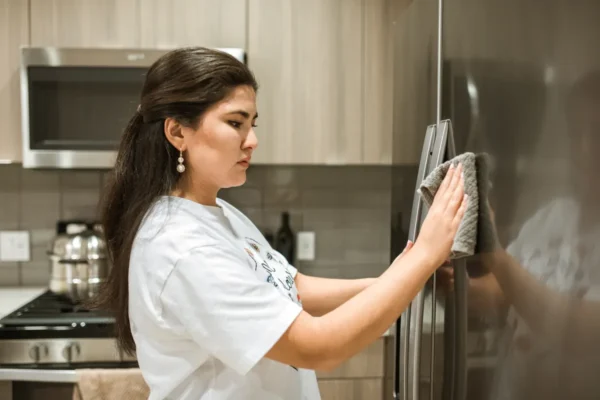 Cleaning the stainless steel refrigerator exterior with a soft microfiber cloth and warm water.