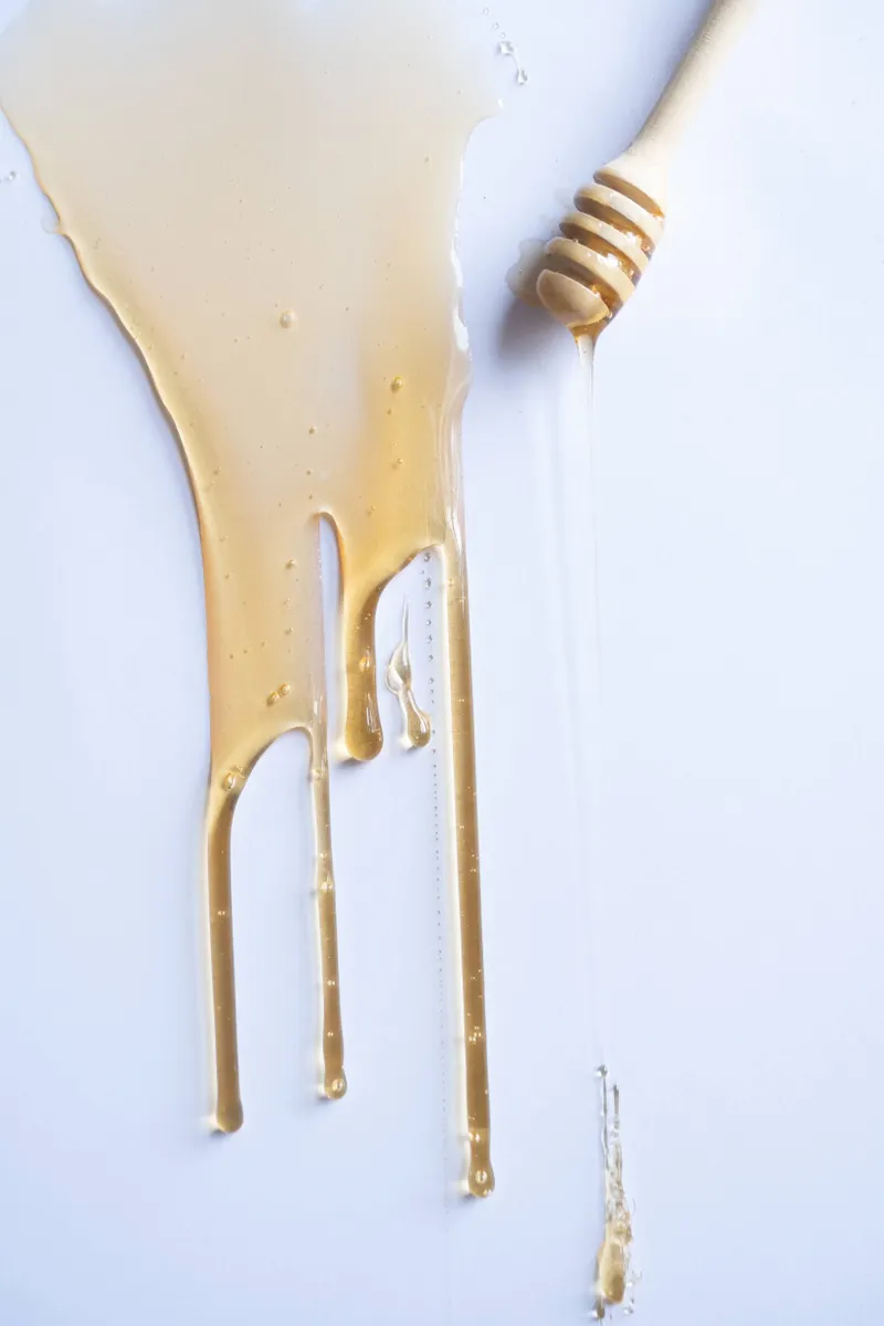 A kitchen cabinet surface showing methods for safely removing sticky syrup residue without damage.