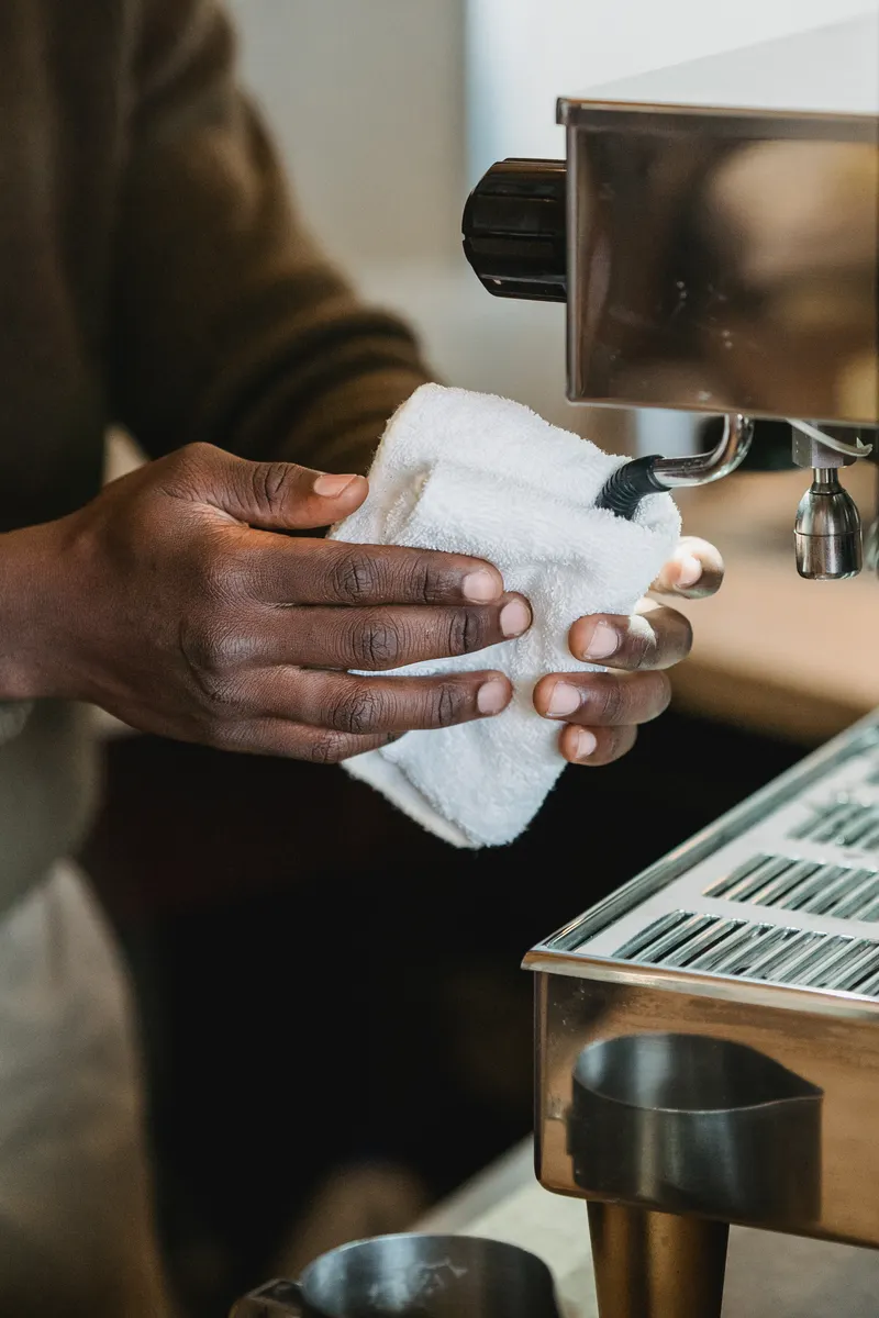 Safe cleaning products and soft cloths arranged for maintaining the coffee maker exterior safely.