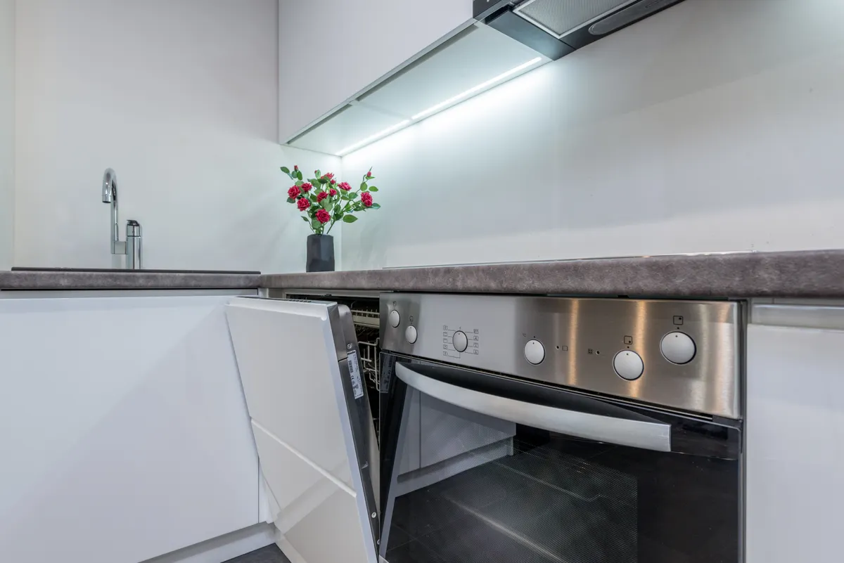 Safe kitchen cleaning supplies including white vinegar and baking soda for appliances.