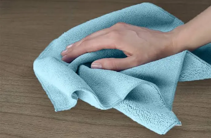 Cleaning supplies including microfiber cloths and mild solutions arranged safely for kitchen use.