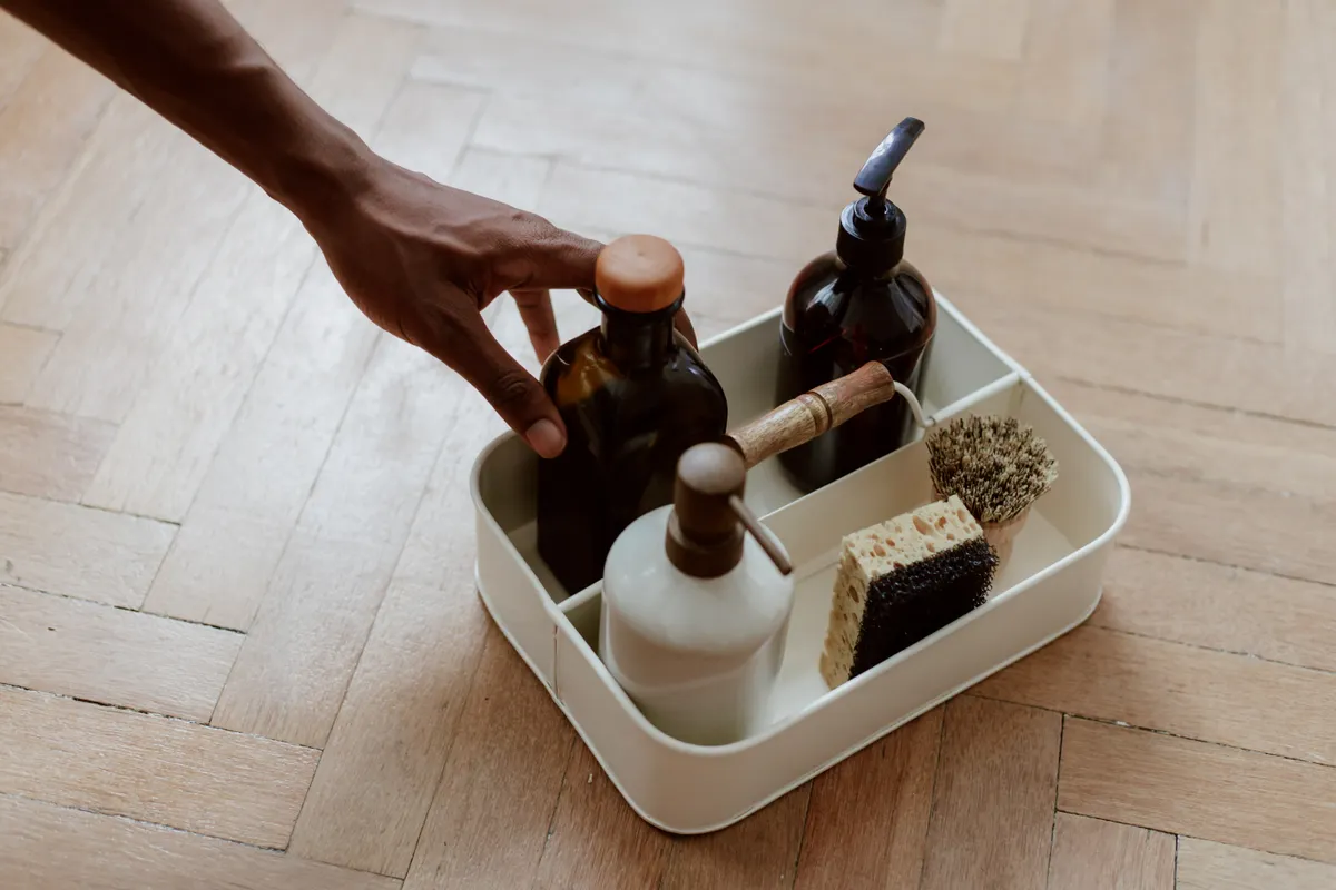 Safe cleaning supplies including dish soap and soft cloths set beside a kitchen microwave.