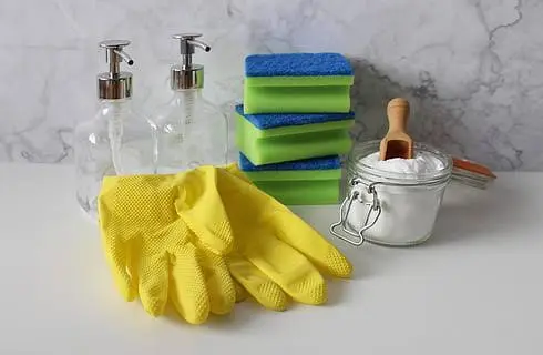 Assorted natural cleaning supplies including dish soap and baking soda lined up for deep cleaning.