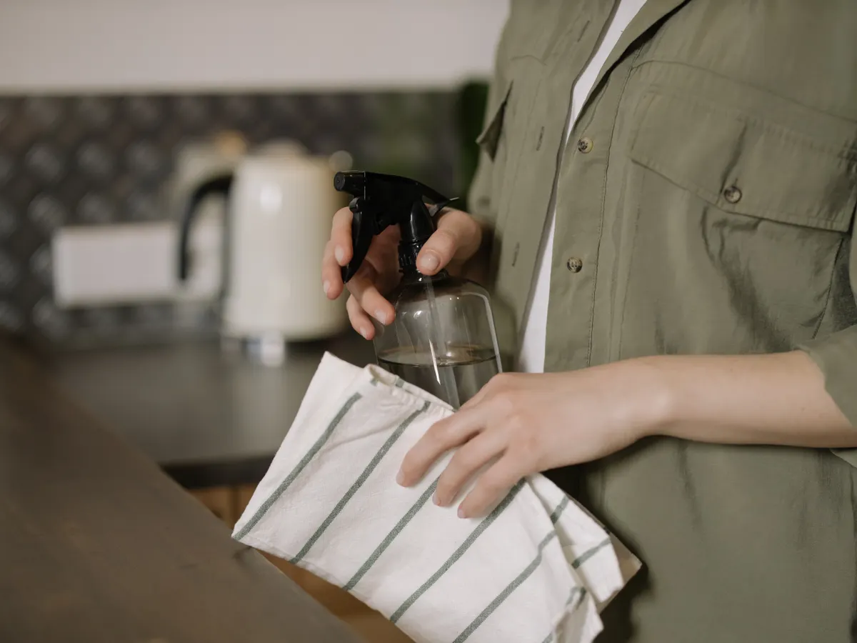 Diluted white vinegar in a spray bottle used for safe kitchen appliance exterior wipe down.